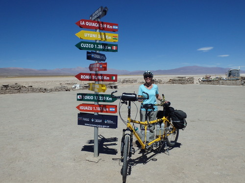 Terry Struck and the Bee with City Name, Distance, and Direction Signs at Salinas Grandes.